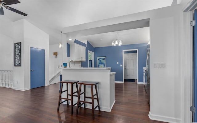 129 Mesero Way, Hot Springs Village, AR 71909 - kitchen with baseboards, dark wood-style flooring, a kitchen breakfast bar, a ceiling fan, and white cabinetry