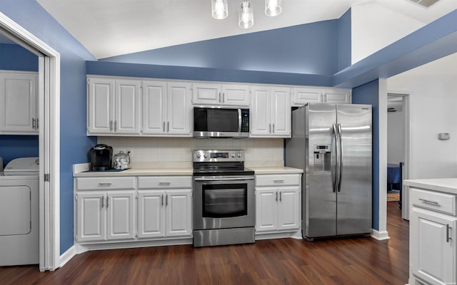 129 Mesero Way, Hot Springs Village, AR 71909 - kitchen featuring appliances with stainless steel finishes, washer / clothes dryer, vaulted ceiling, light countertops, and dark wood-style flooring
