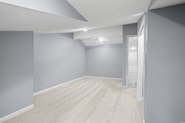 finished basement with carpet flooring, a textured ceiling, and baseboards