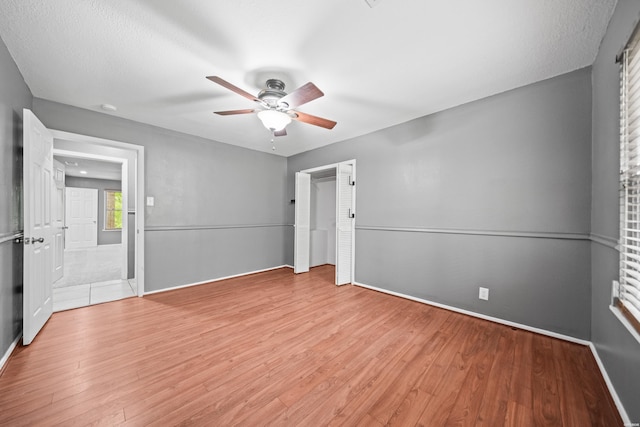 unfurnished bedroom with wood finished floors, baseboards, and a ceiling fan