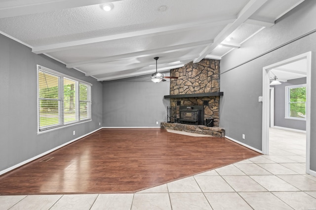 unfurnished living room with a ceiling fan, wood finished floors, a textured ceiling, and baseboards