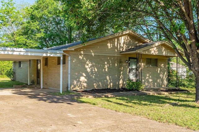 view of front of house with concrete driveway, brick siding, and an attached carport
