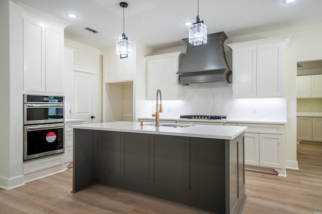 135 Ridgeway Pl, Hot Springs, AR 71901 - kitchen with a sink, appliances with stainless steel finishes, wall chimney exhaust hood, light countertops, and light wood-type flooring