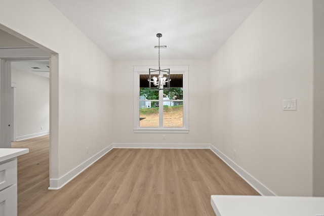 135 Ridgeway Pl, Hot Springs, AR 71901 - unfurnished dining area with light wood-style floors, a chandelier, and baseboards