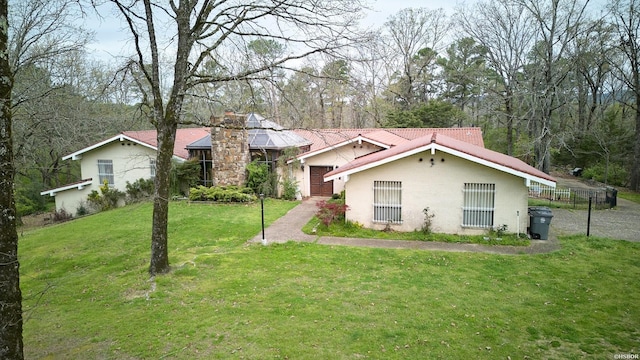 view of front of home with fence, a chimney, and a front lawn