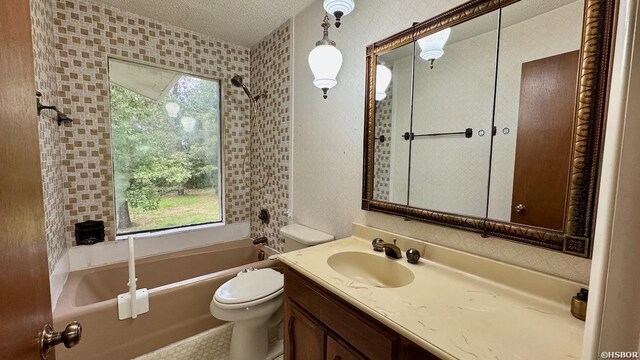 full bath with a wealth of natural light, a textured ceiling, toilet, and vanity