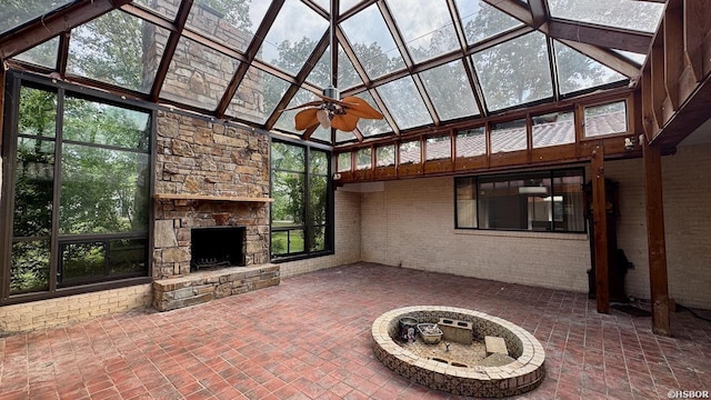 unfurnished sunroom featuring a skylight, ceiling fan, and a fireplace