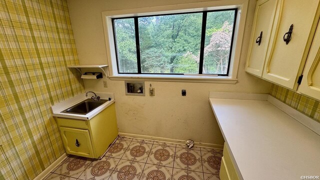 laundry area with hookup for a washing machine, cabinet space, a sink, and wallpapered walls