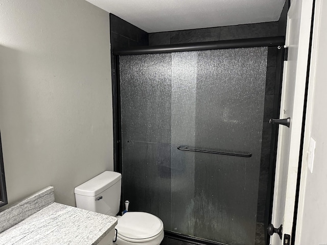 full bath with a stall shower, vanity, and toilet