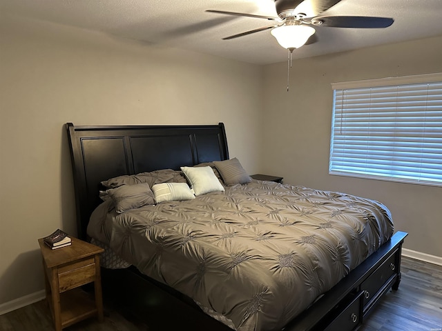 bedroom featuring dark wood-style floors, baseboards, and a ceiling fan