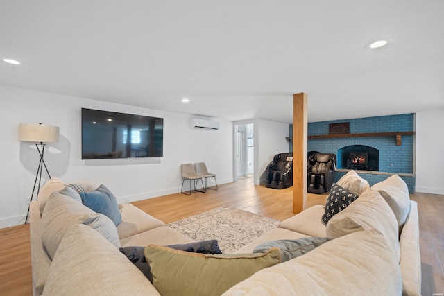 living area with light wood-type flooring, a brick fireplace, recessed lighting, and a wall mounted AC