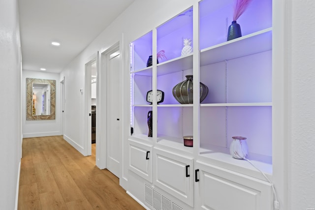 hall with light wood-type flooring, baseboards, and recessed lighting