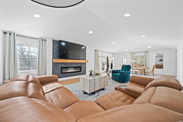 living room with a large fireplace, plenty of natural light, vaulted ceiling, and recessed lighting