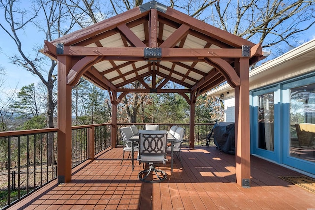 deck featuring outdoor dining space, a grill, and a gazebo