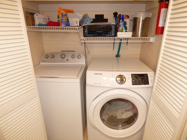 clothes washing area featuring laundry area and washer and clothes dryer