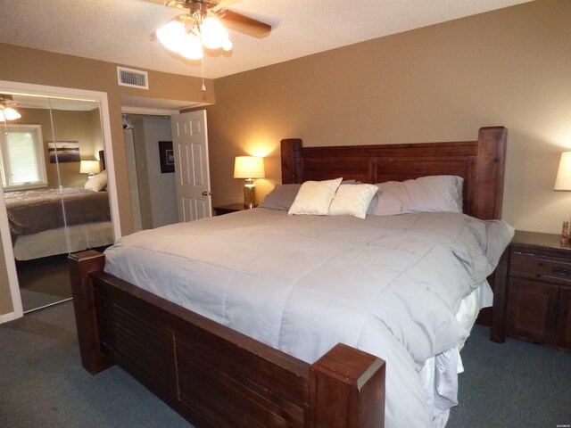 bedroom with dark colored carpet, a closet, visible vents, and a ceiling fan