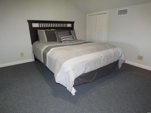 bedroom featuring lofted ceiling, visible vents, dark carpet, and baseboards