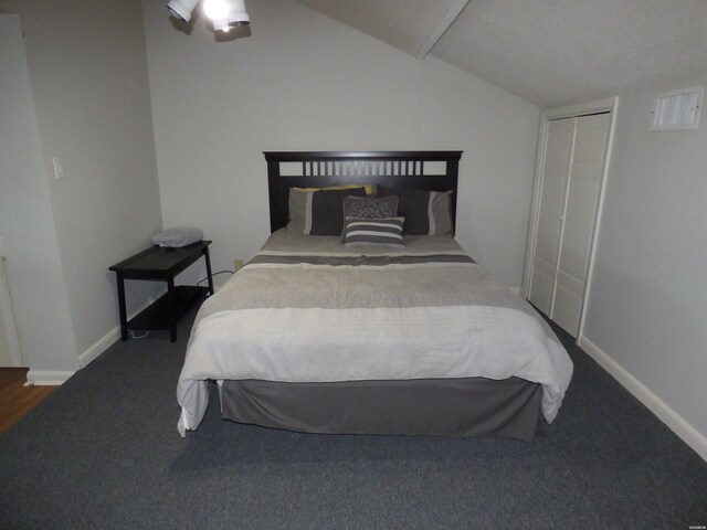 bedroom with lofted ceiling, a closet, carpet flooring, and baseboards