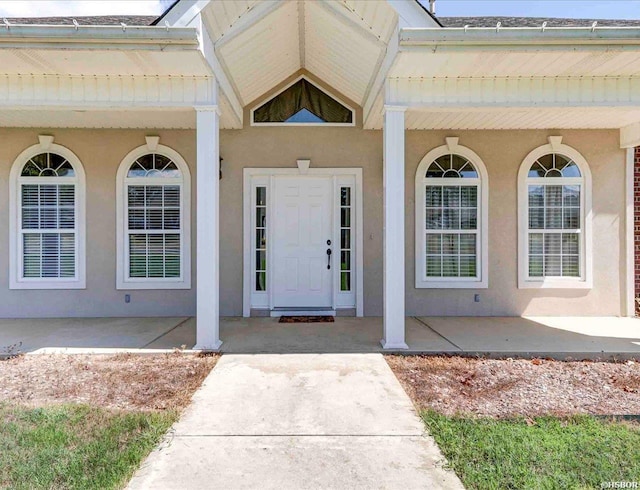 doorway to property featuring stucco siding