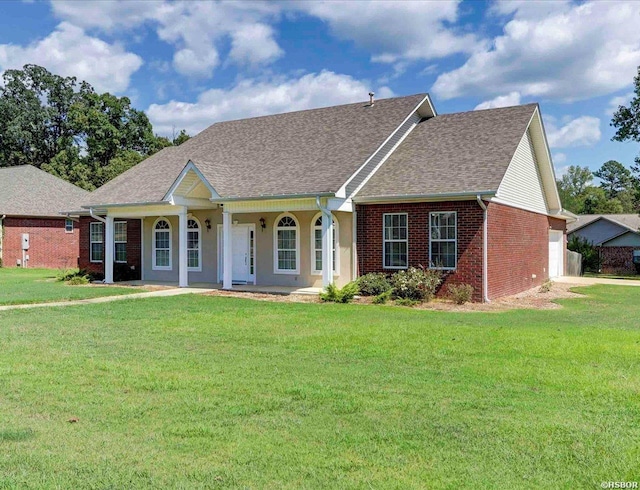 ranch-style home featuring a porch, a garage, brick siding, a shingled roof, and a front lawn