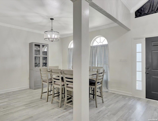 dining area featuring a notable chandelier, ornamental molding, light wood-style flooring, and baseboards