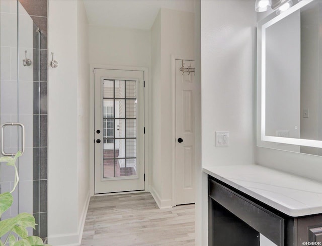 doorway to outside with light wood-type flooring, baseboards, and wine cooler