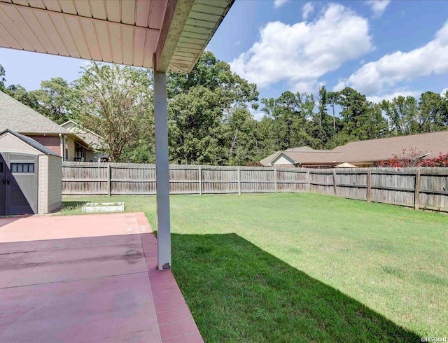 view of yard featuring a storage shed, a fenced backyard, an outdoor structure, and a patio