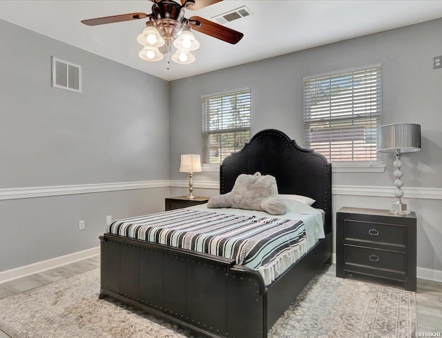 bedroom featuring multiple windows, visible vents, and light wood-style floors