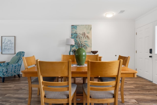 dining area featuring visible vents, crown molding, and wood finished floors