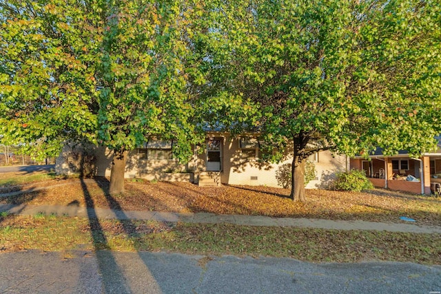 view of side of property with crawl space and brick siding