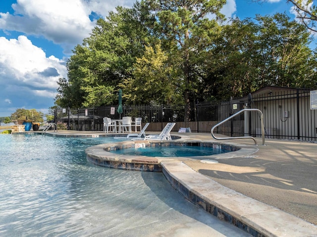 pool with a patio area and fence