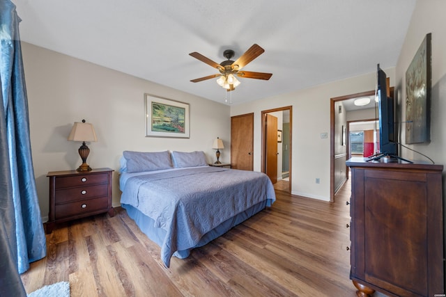 bedroom with a ceiling fan, baseboards, and wood finished floors