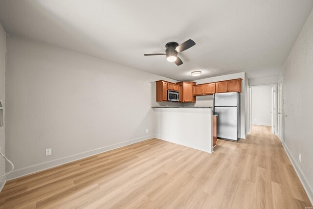 183 River Mill Ct Unit B-1, Hot Springs, AR 71913 - kitchen featuring appliances with stainless steel finishes, a peninsula, brown cabinets, light wood-style floors, and ceiling fan