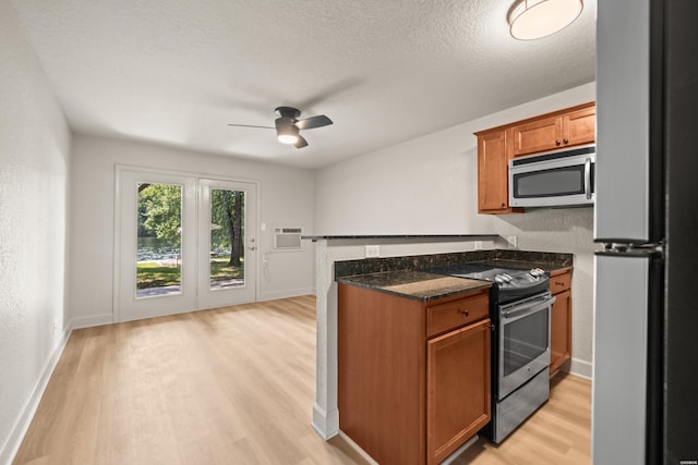 183 River Mill Ct Unit B-1, Hot Springs, AR 71913 - kitchen with stainless steel appliances, brown cabinets, light wood-style floors, a ceiling fan, and dark stone countertops