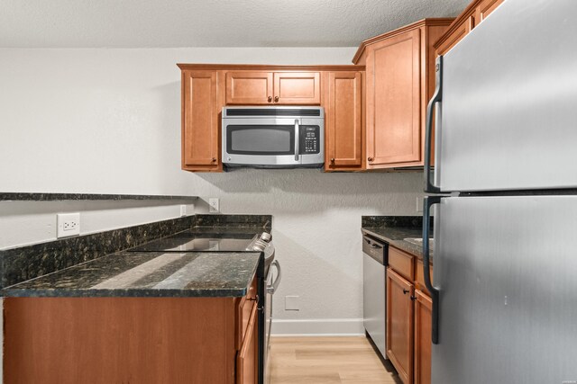 183 River Mill Ct Unit B-1, Hot Springs, AR 71913 - kitchen with appliances with stainless steel finishes, light wood finished floors, brown cabinets, and dark stone countertops