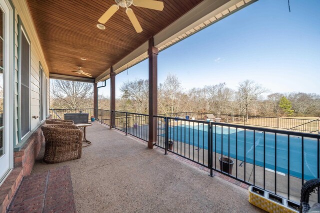 exterior space featuring ceiling fan, fence, and a fenced in pool