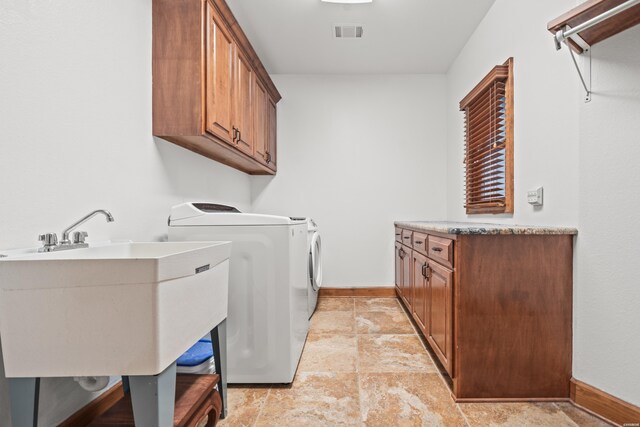 laundry area with a sink, visible vents, baseboards, independent washer and dryer, and cabinet space