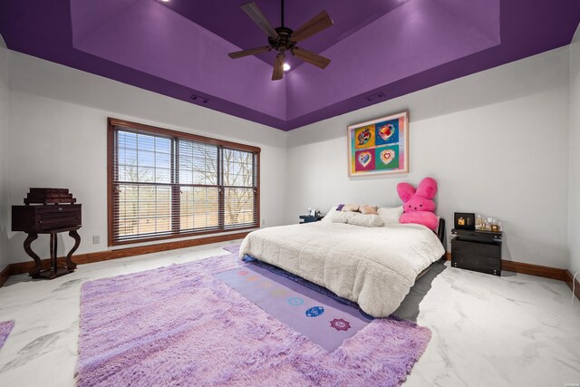 bedroom featuring a raised ceiling, ceiling fan, marble finish floor, and baseboards