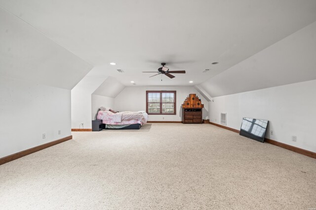 unfurnished bedroom featuring lofted ceiling, carpet floors, baseboards, and visible vents