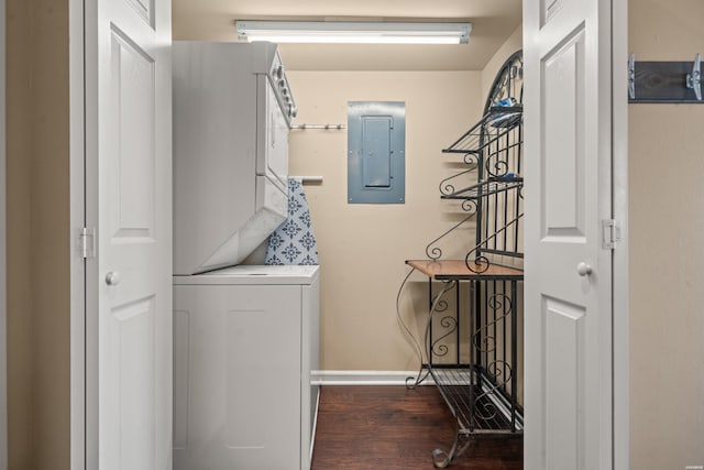 washroom featuring stacked washer and dryer, electric panel, dark wood finished floors, and baseboards