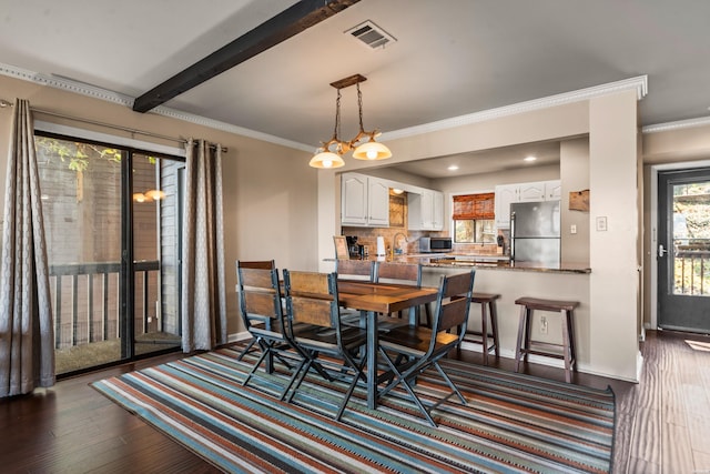 dining area featuring crown molding, dark wood finished floors, visible vents, and baseboards