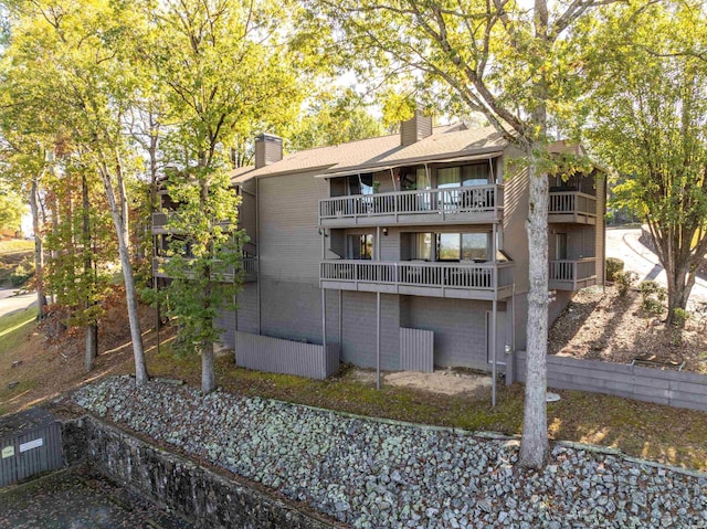 rear view of property with a chimney and a balcony