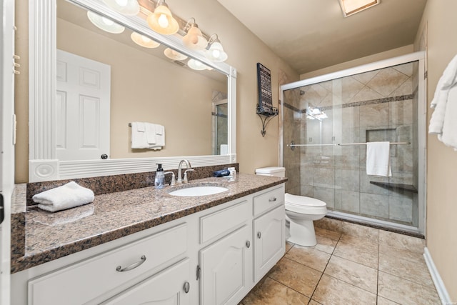 bathroom with toilet, vanity, a shower stall, and tile patterned floors