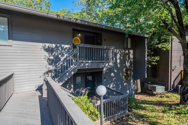 exterior space with stairs, a deck, and cooling unit