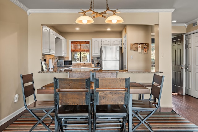 dining area featuring dark wood-style flooring, crown molding, recessed lighting, visible vents, and baseboards