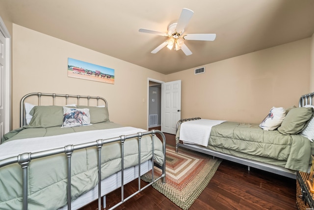 bedroom featuring a ceiling fan, visible vents, and dark wood-style flooring