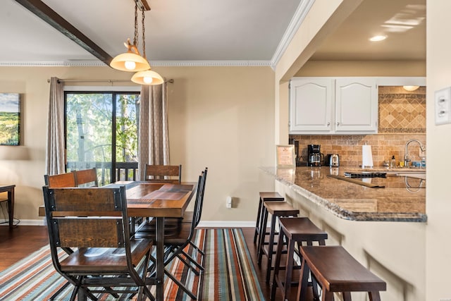 dining area with ornamental molding, dark wood-type flooring, and baseboards