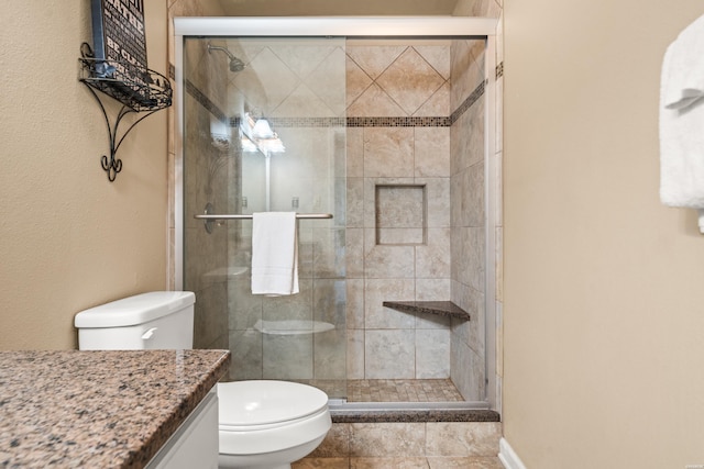 full bath with a stall shower, vanity, and toilet