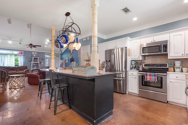 114 Cliffwood Loop, Hot Springs, AR 71913 - kitchen featuring appliances with stainless steel finishes, crown molding, a kitchen breakfast bar, white cabinetry, and recessed lighting