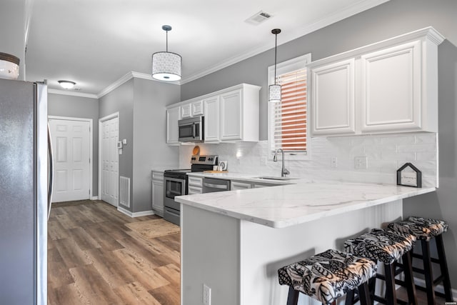 128 Kaleigh Ct Unit B, Hot Springs, AR 71913 - kitchen with stainless steel appliances, a sink, a peninsula, light stone counters, and light wood finished floors